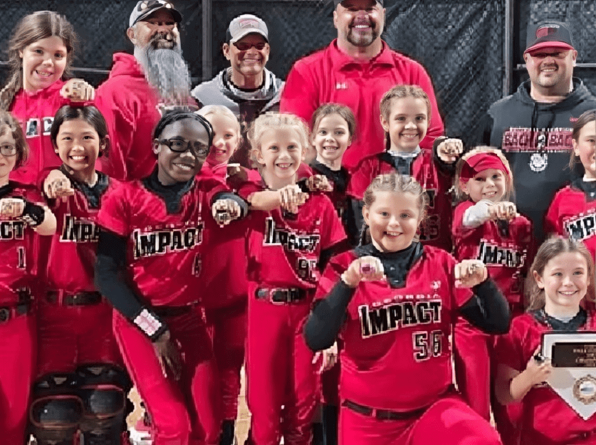Youth softball team celebrating with trophies.