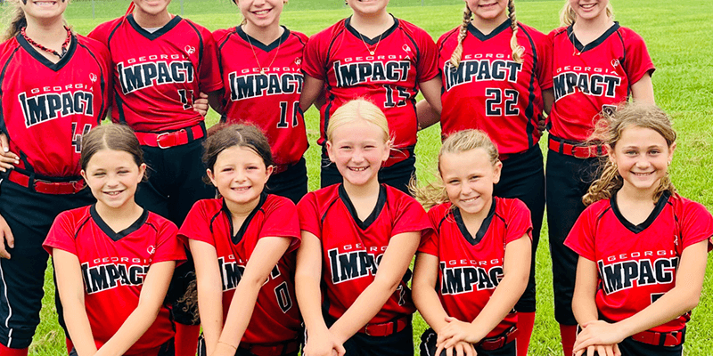 Smiling youth softball team in red Impact jerseys