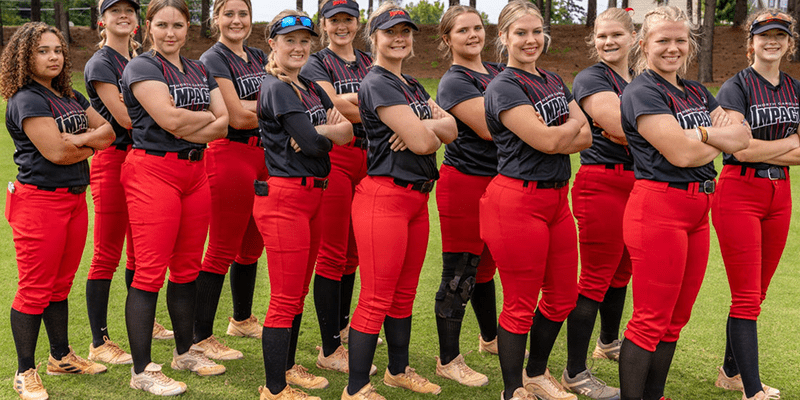 Softball team posing in red and black.