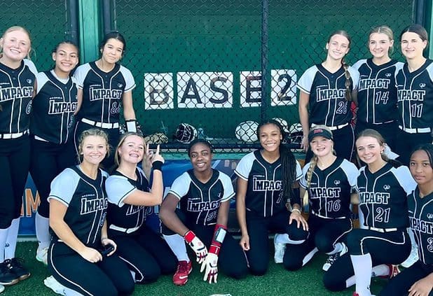 Softball team posing in uniforms together.