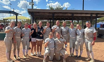 Softball team posing together on the field.