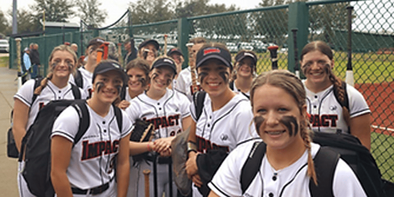 Softball team smiling before a game.
