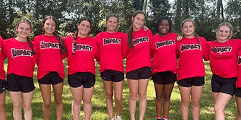 Group of girls in red "Impact" shirts.