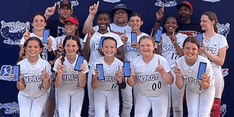 Youth softball team holding blue award ribbons