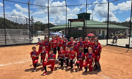 Softball team poses on baseball field.