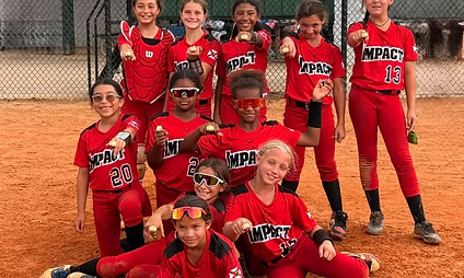 Youth softball team posing in red uniforms.