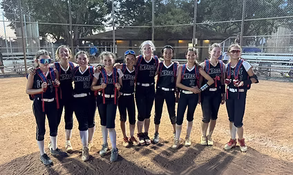 Softball team posing on the field together.