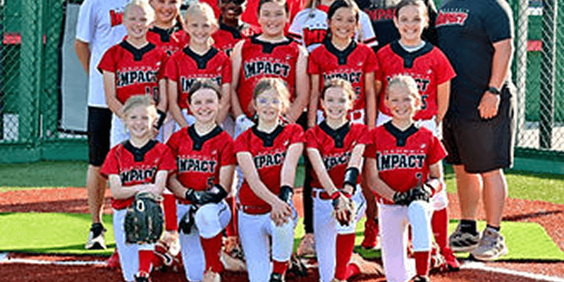 Smiling girls softball team in red jerseys