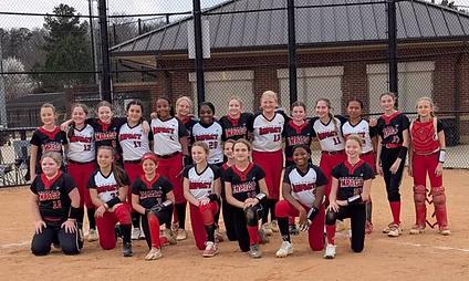 Youth softball teams posing together on field