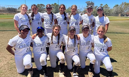 Girls' softball team posing on field.