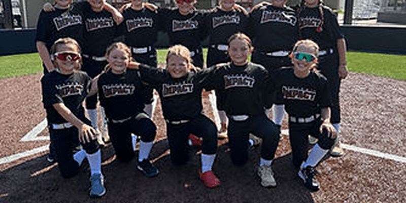 Youth softball team posing on home plate
