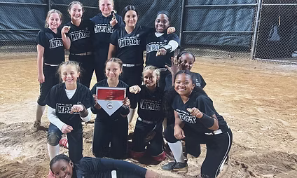 Softball team posing with trophy and medals.