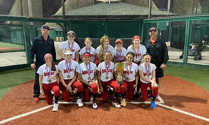 Youth softball team with trophy on field.