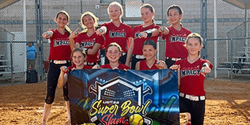 Youth girls softball team holding Super Bowl banner
