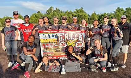 Smiling softball team holding championship banner