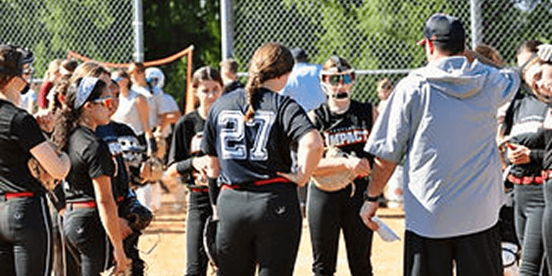 Softball team huddled during a game.