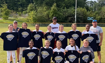 Softball team posing with black shirts.