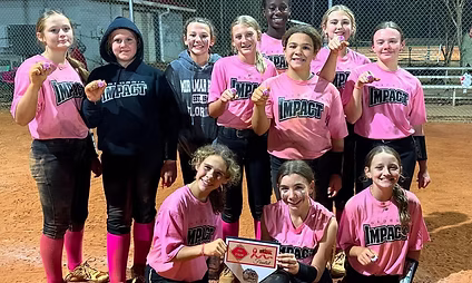 Softball team celebrating with trophy and medals.