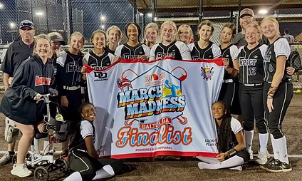 Softball team holding "March Madness" finalist banner.