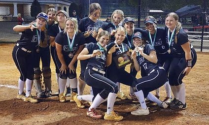 Softball team celebrating with medals and trophy.