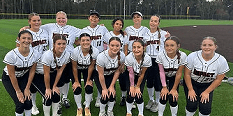 Smiling women's softball team posing on field