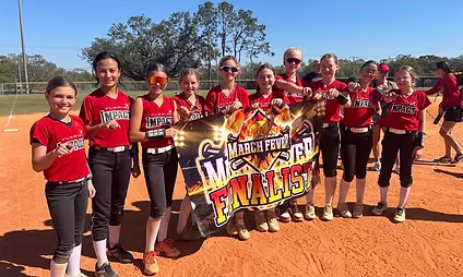 Youth softball team holding finalist banner