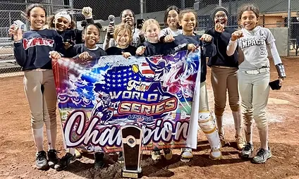 Girls softball team holding championship banner and trophy