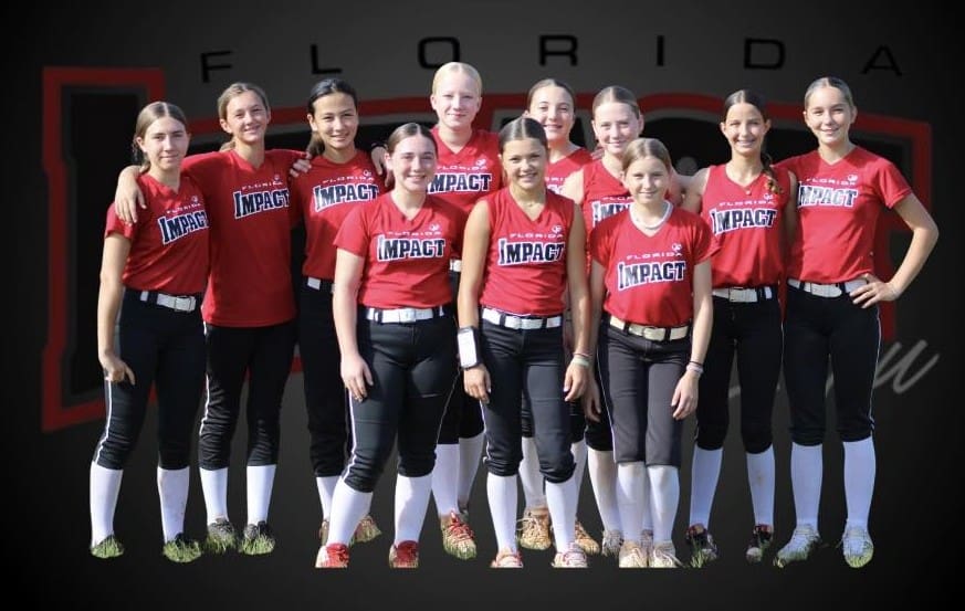 A girls' softball team poses in matching red and black uniforms.