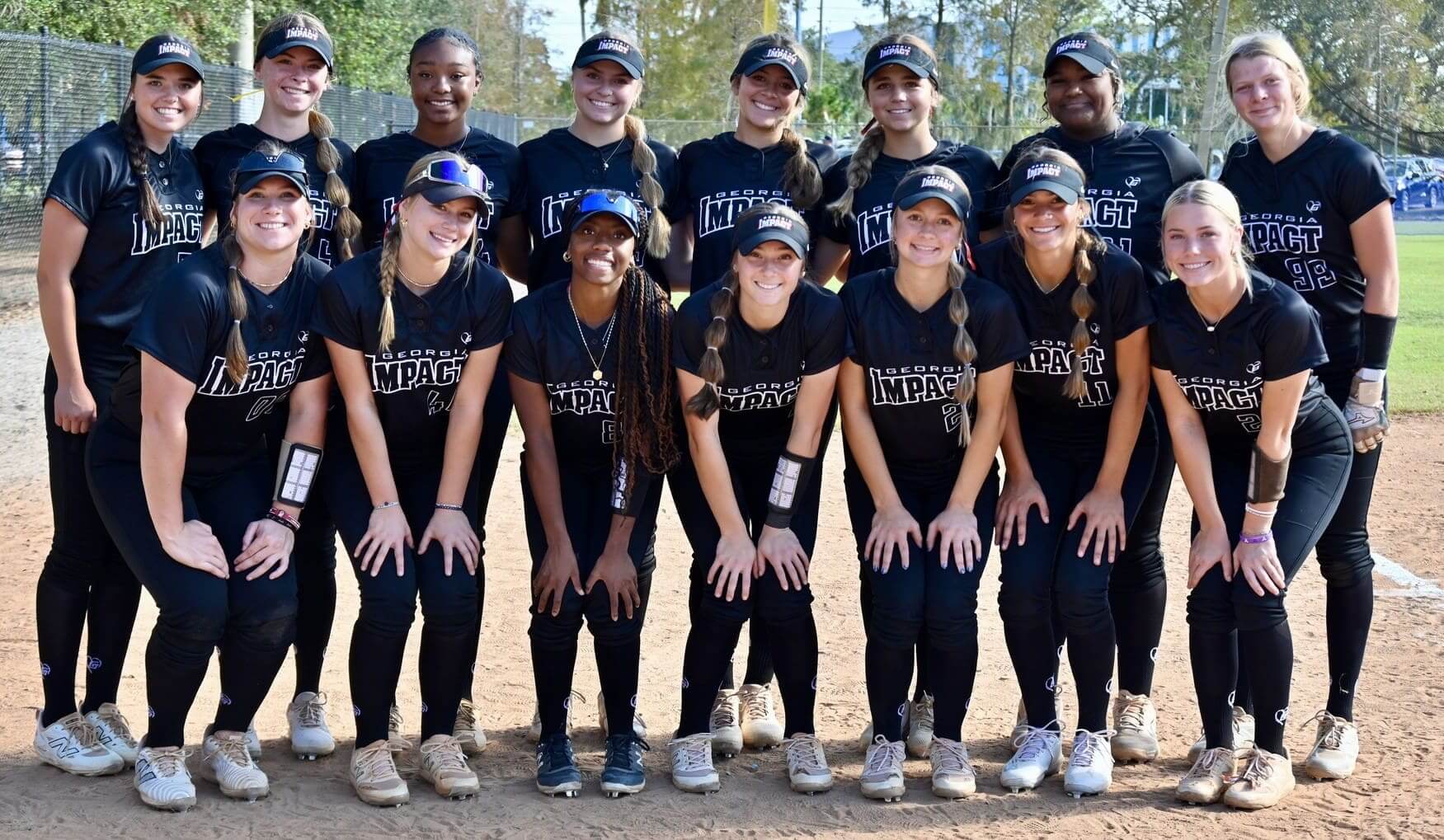 Youth softball team posing for a group photo on the field.