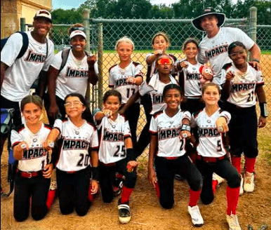 Girls' softball team posing proudly after a game.
