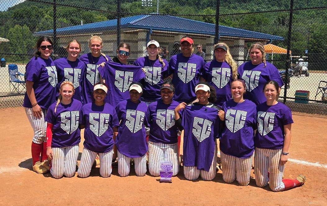 Softball team wearing purple shirts on field